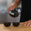 Ensemble théière et deux tasses émaillées noires aux herbes